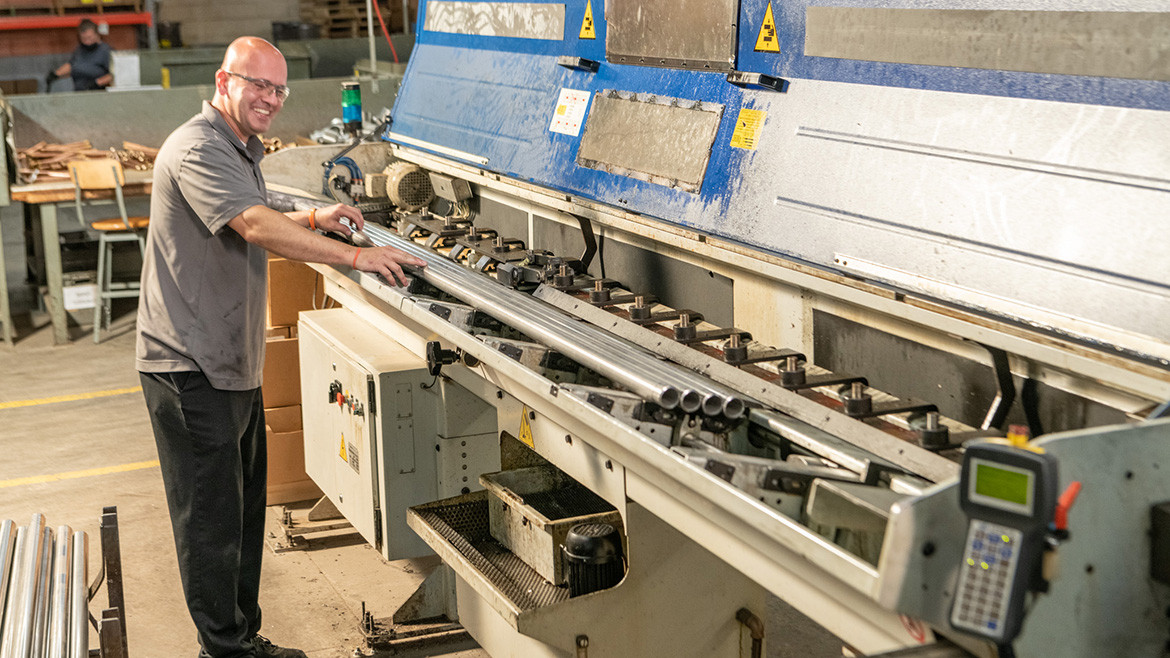 Pat Joslin operating a CNC with metal tubes.