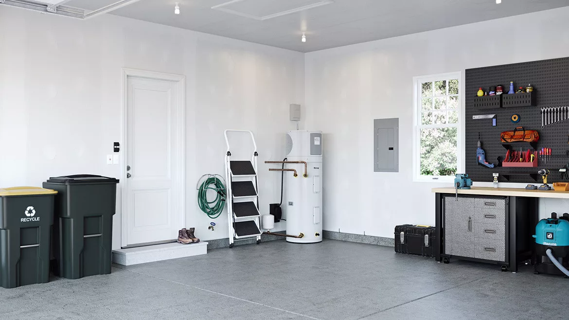 Water Heater REHP Series installed in the corner of a garage, ladder next to it, two bins, and a worktable.