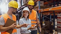 A female manager, along with two warehouse workers, is inspecting the merchandise.
