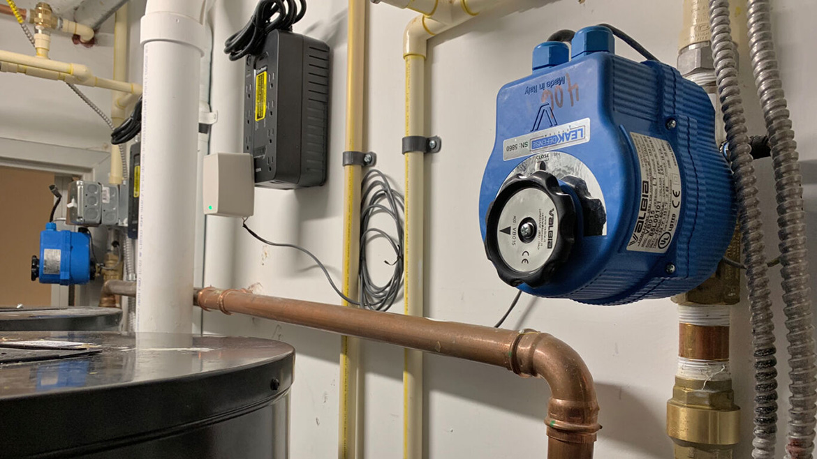 Utility room plumbing: water heater, Valbia LEAKDEFENSE valve, various pipes, and smart home tech