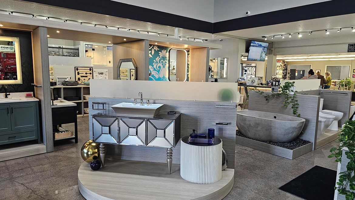 Mountain Supply Co. bathroom showroom with various vanities, sinks, and a stone bathtub on display.