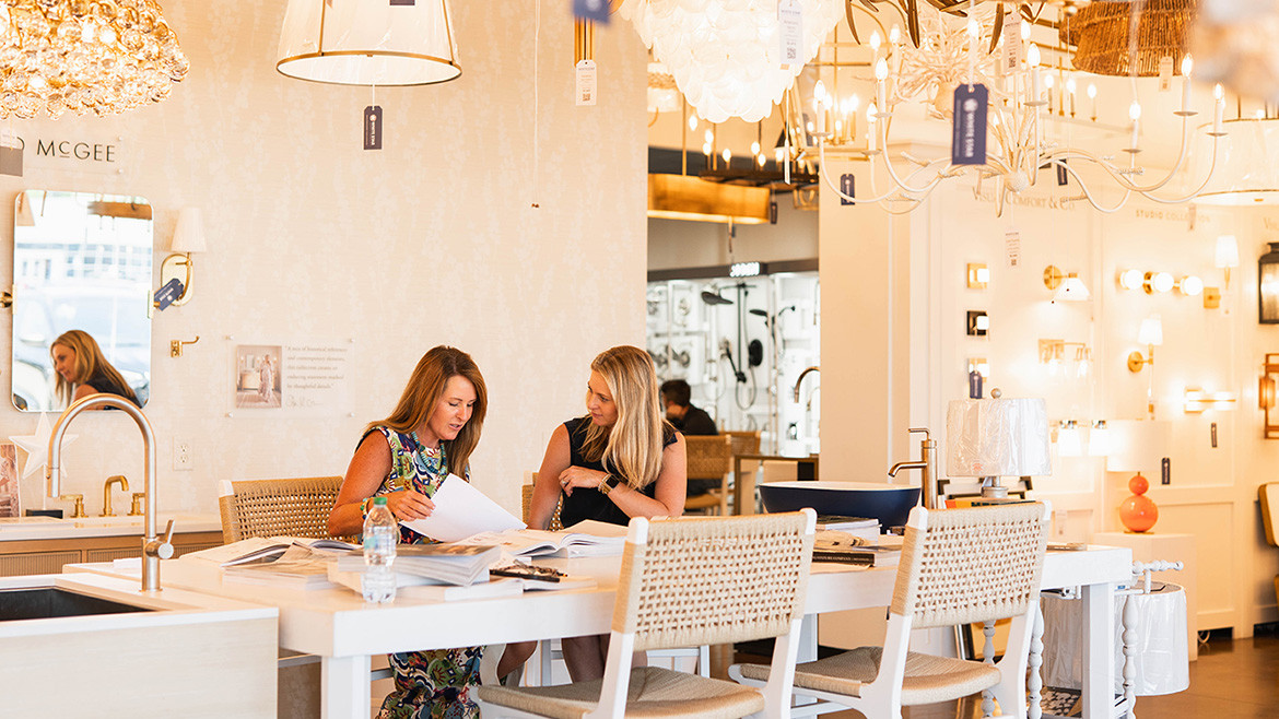 Two women having a meeting inside a stylish lighting showroom.