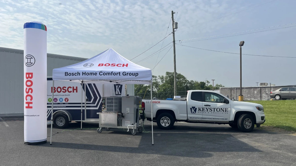 Bosch tent, equipment, blowup, and trailer set up next to Keystone Sales & Associates pickup truck