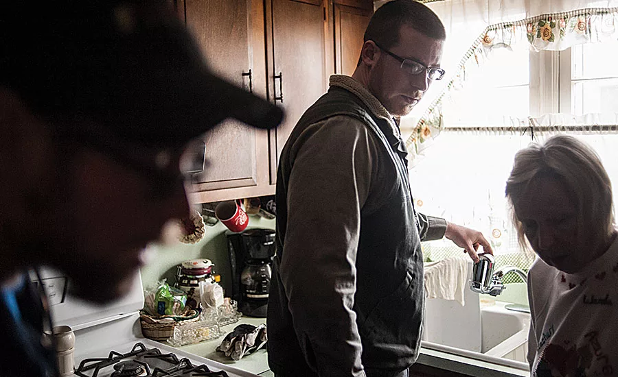 A local plumbing contractor installs a filter in a Flint resident's home