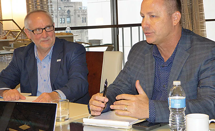 Texas Plumbing Supply’s Fuller (right) answers a question as EPSCO’s Jones looks on