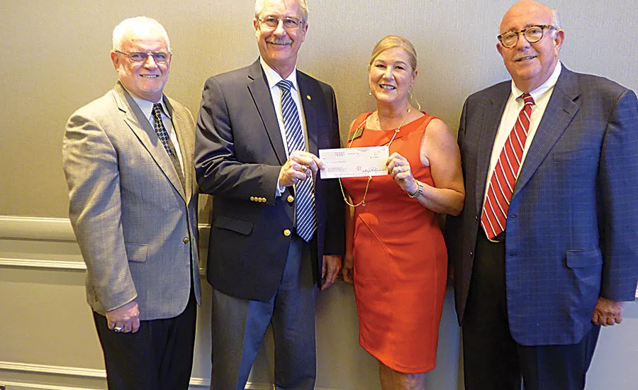 San Jacinto College’s Kevin Morris (second from left) and Ruth Keenan (second from right) display a scholarship check for $25,000 at the PVF Roundtable’s fall meeting in Houston